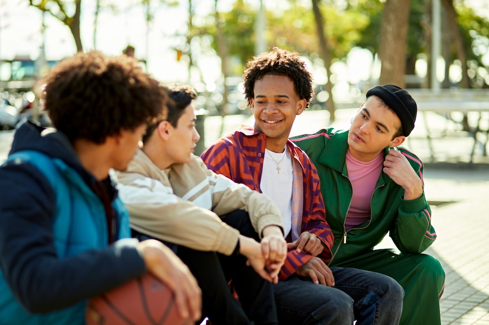 relaxed group sitting outdoors in sunshine and talking